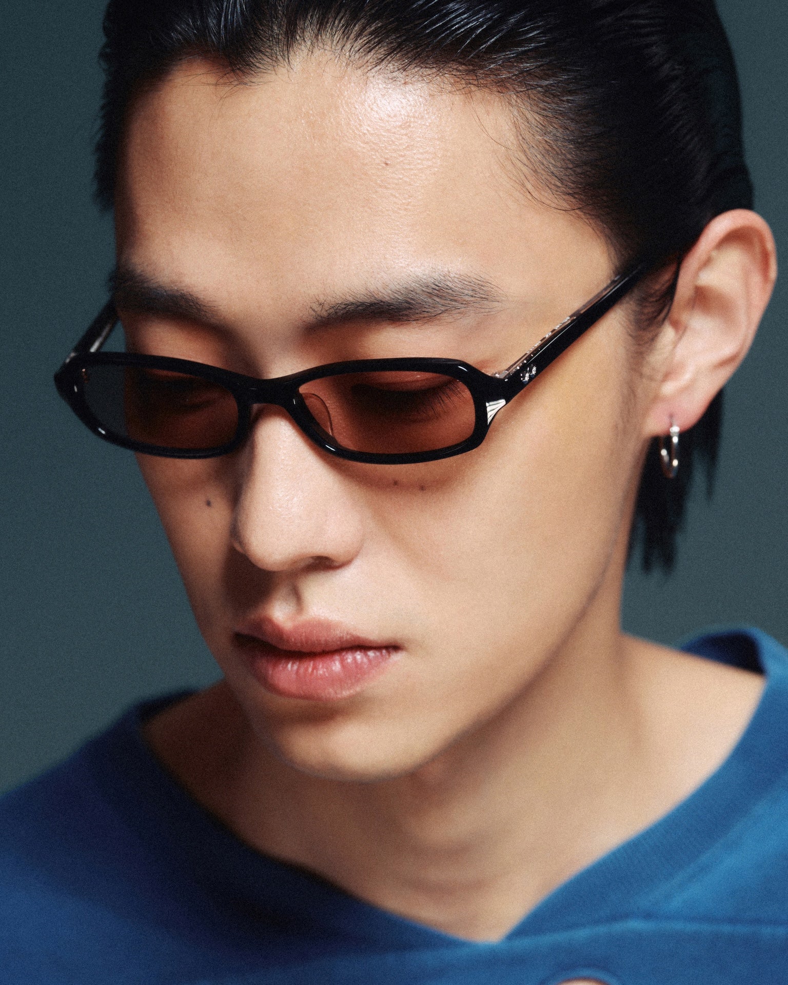 Model wearing slim black sunglasses